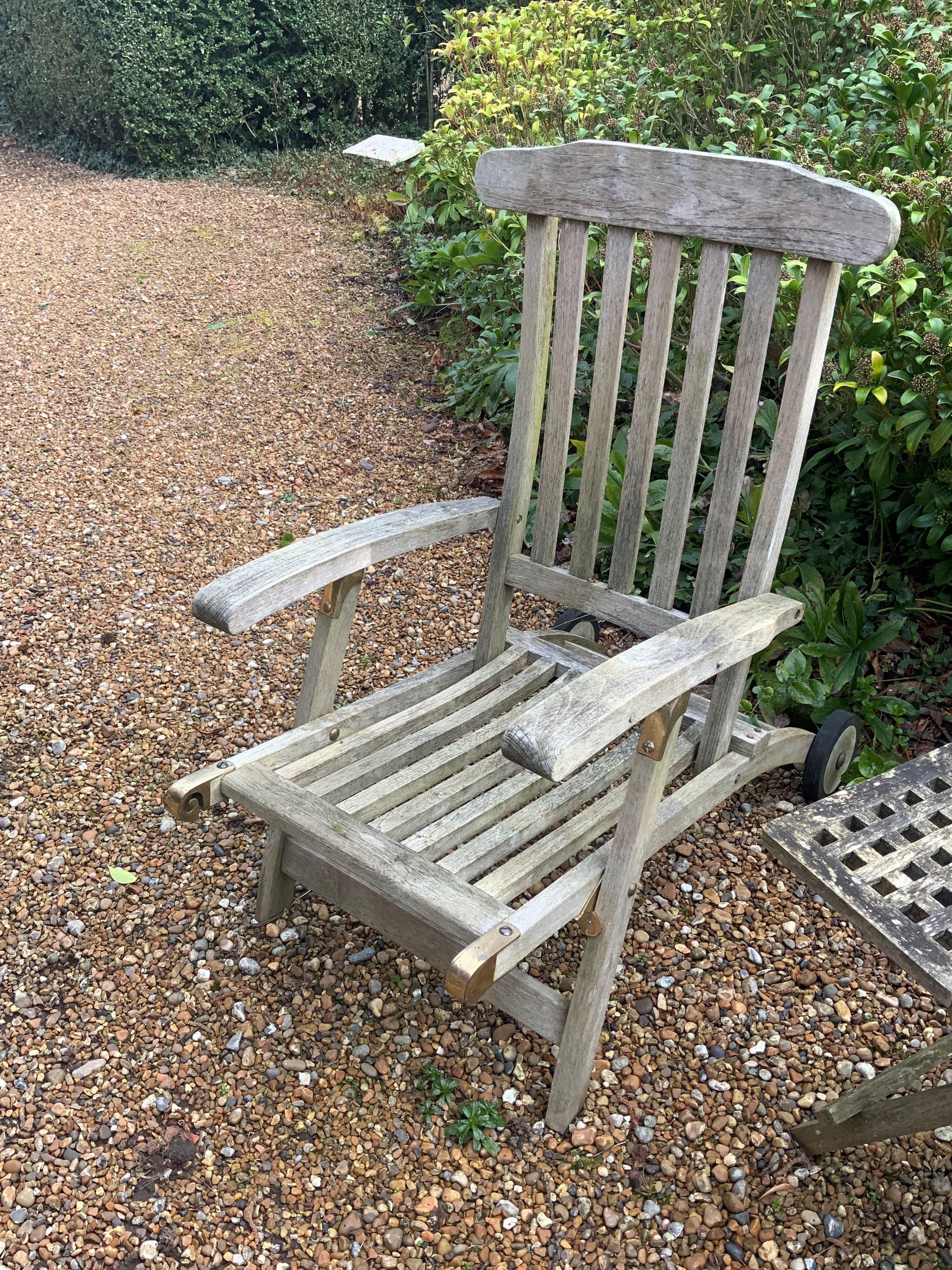 A pair of slatted weathered teak garden steamer chairs, width 59cm, height 97cm